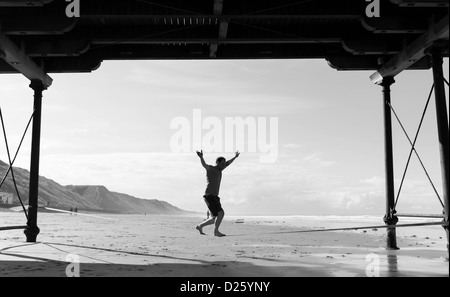 Ein Mann übt seine Fähigkeiten auf einer "Slack-Line" zwischen die Beine von Saltburn Pier in Cleveland gebunden. Stockfoto