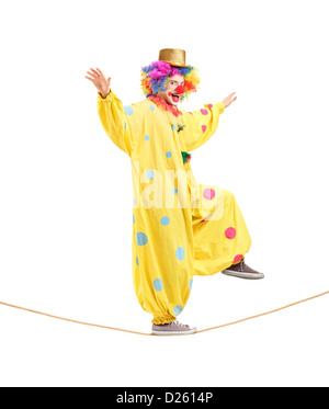In voller Länge Portrait eines glücklichen männlichen Clown zu Fuß auf einem Seil isoliert auf weißem Hintergrund Stockfoto