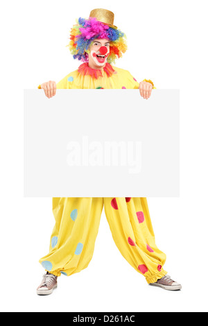 In voller Länge Portrait eines männlichen Clowns mit glücklichen freudigen Ausdruck hält eine Blindplatte isoliert auf weißem Hintergrund Stockfoto