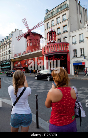 Frauen schießen auf das berühmte Moulin Rouge in Paris. Pigalle Bereich, Frankreich Stockfoto