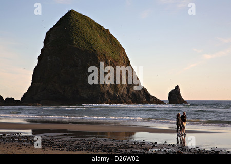Ein paar Spaziergänge entlang der Cannon Beach in der Nähe von Haystack Rock in Oregon, USA Stockfoto