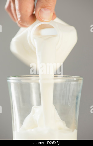 Hand gießen Milch Stockfoto