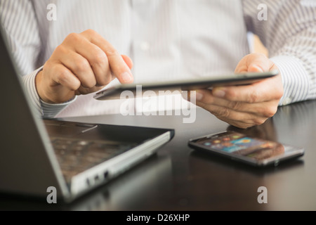 USA, New Jersey, Jersey City, Mann mit tablet-pc, Laptop und smartphone Stockfoto