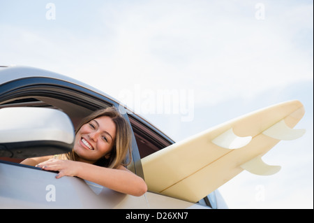 USA, New York State, Rockaway Beach, Frau Steuerwagen mit Surfbrett im Inneren Stockfoto