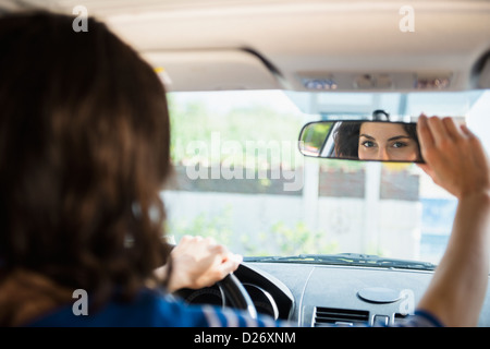USA, New York State, Rockaway Beach, Frau Anpassung Rückspiegel im Auto Stockfoto