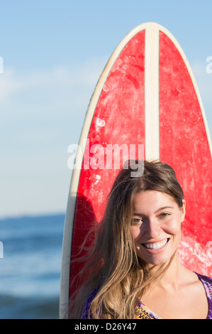 USA, New York State, Rockaway Beach, Portrait Frau mit Surfbrett Stockfoto