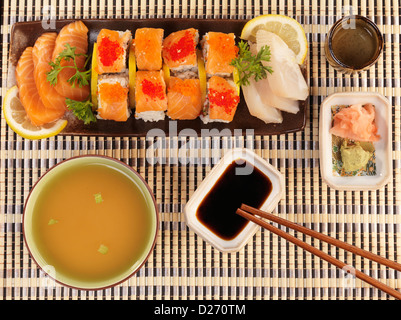 Serviert Sushi Rolls, Sashimi, Schüssel mit Miso, Sake und Stäbchen Stockfoto