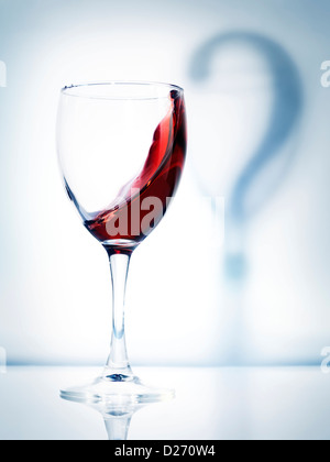 Glas Rotwein und ein Schatten Fragezeichen künstlerische konzeptionelle Foto auf hellblauem Hintergrund isoliert Stockfoto