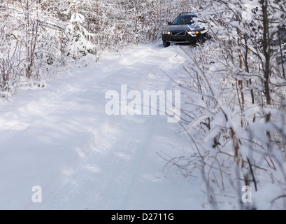 Volvo XC70 Auto auf Schnee bedeckt unbefestigte Landstraße, malerische Winterlandschaft. Stockfoto