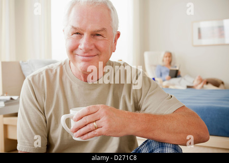 Senior woman Kaffeetasse halten und Lächeln Stockfoto