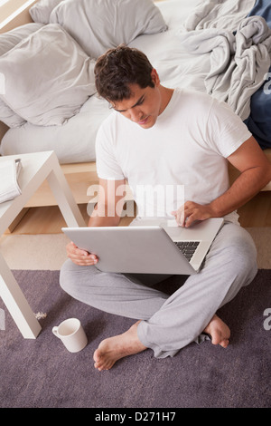 Junge Männer im Pyjama mit laptop Stockfoto
