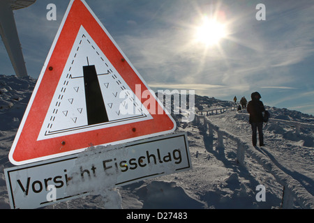 Wanderer gehen auf Brocken Berg vorbei ein Schild Warnung von Eisschlag in Schierke, Deutschland, 15. Januar 2013. Heine schrieb über ihn, Reise in den Harz im Jahr 1824 und seinen Aufenthalt im Hotel Brocken. Foto: MATTHIAS BEIN Stockfoto