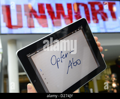 ILLUSTRATION - hält eine Hand ein i-Pad, die das Schlimmste Wort des Jahres 2012 «Opfer-Abo» (lit. Abonnement Opfer) bei einer Pressekonferenz in Darmstadt, Deutschland, 15. Januar 2013 zeigt. Sie Schlüssel Wort geht zurück auf Schweizer Moderator Joerg Kachelmann, der im Herbst 2012 gesagt hat, dass Frauen in der Gesellschaft eine «Opfer-Abo» (wörtl. Abonnement Opfer). Foto: Arne Dedert Stockfoto