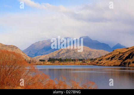 Lake Hayes und Blick auf Cecil Peak in Bergen im Herbst in der Nähe von Arrowtown, Southern Lakes, Otago, Südinsel, Neuseeland. Stockfoto