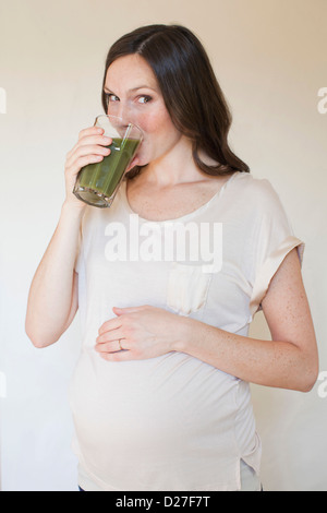 USA, Utah, Salt Lake City, Porträt von schwangeren Mitte Erwachsene Frau grünen Saft trinken Stockfoto