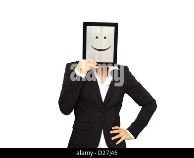 Geschäftsfrau, die sich hinter einem digitalen Tablet mit einem fröhlichen Smiley-Gesicht versteckt. Stockfoto