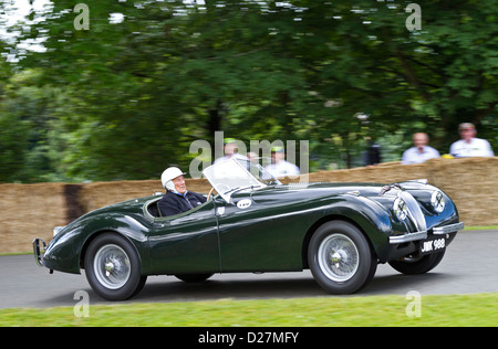 Jaguar XK120 1949 mit Fahrer Sir Stirling Moss auf dem 2012 Goodwood Festival of Speed, Sussex, UK. Stockfoto