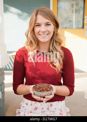 USA, Utah, Provo, Porträt der jungen Frau Holding Schüssel mit Pinienkernen Stockfoto
