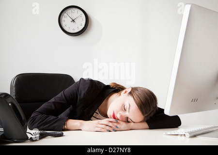 Studioaufnahme von junge Frau arbeitet im Büro ein Nickerchen Stockfoto