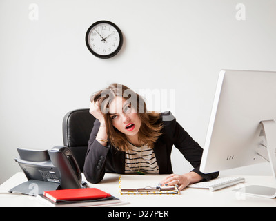 Studioaufnahme der jungen Frau, die Arbeiten im Büro unter emotionalem stress Stockfoto