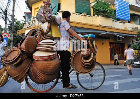 Mann auf einem Fahrrad verkaufen Stroh Schalen und Hüte, Hanoi, Vietnam Stockfoto