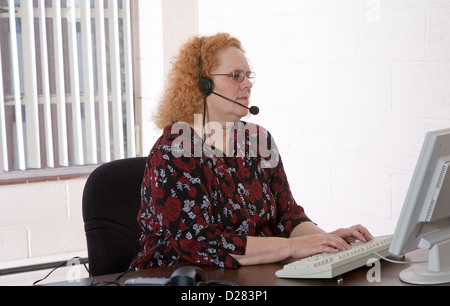 Produktive mittlere gealterte Frau arbeitet in einem Callcenter Stockfoto