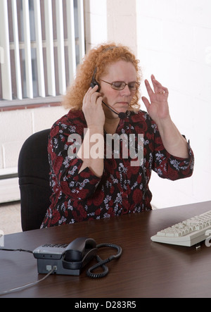 Produktive mittlere gealterte Frau arbeitet in einem Callcenter Stockfoto