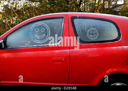 Smiley-Gesichter auf frostigen Autoscheiben Stockfoto