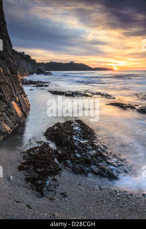 Sonnenaufgang von Falmouth Gyllyngvase Strand mit Pendennis Castle in der Ferne erfasst. Stockfoto