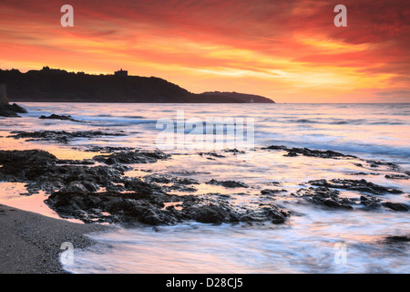 Sonnenaufgang von Falmouth Gyllyngvase Strand mit Pendennis Castle in der Ferne erfasst. Stockfoto