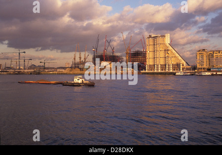 Thames Schlepper vorbei am Flussufer Bau der 1980er Jahre auf der Isle of Dogs, 1989. (Piers Gough Gebäude Kaskaden Mitte-rechts) Stockfoto