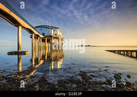 Die RNLI Station auf Roa Island in der Nähe von Barrow in Furness in Cumbria, mit dem Schloss auf Piel Insel lebensfähig in der Ferne. Stockfoto