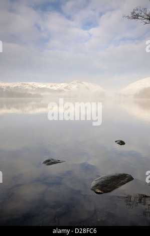 Clearing Schneewolke über Grasmere und Helm Crag im Winter im englischen Lake District Stockfoto