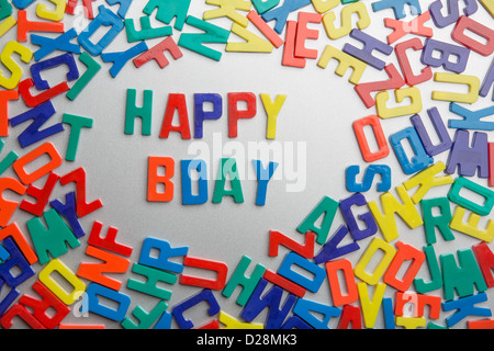 "Happy Bday" - Kühlschrank-Magnete buchstabieren Nachrichten aus einem Durcheinander von Buchstaben Stockfoto