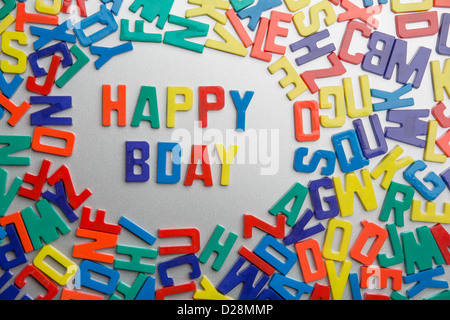 'Happy Bday' - Zauber Kühlschrankmagneten eine Nachricht aus einem Durcheinander von Buchstaben Stockfoto