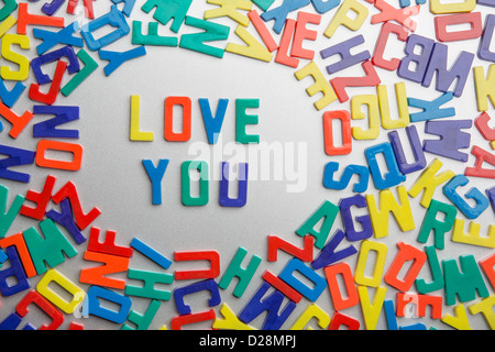 "Liebe dich" Kühlschrank-Magnete buchstabieren Nachrichten aus einem Durcheinander von Buchstaben Stockfoto