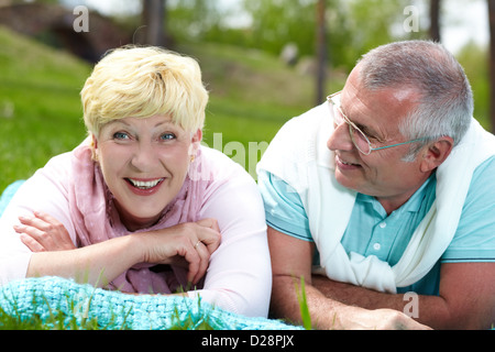 Gerne älteres paar liegen auf dem Rasen und die Erholung im Sommer Stockfoto