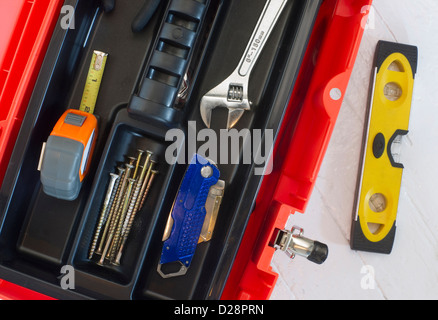 Orange Werkzeugkasten mit Halbmond messen Band Level Boxcutter Schrauben und Mehrzweck-Werkzeug Stockfoto