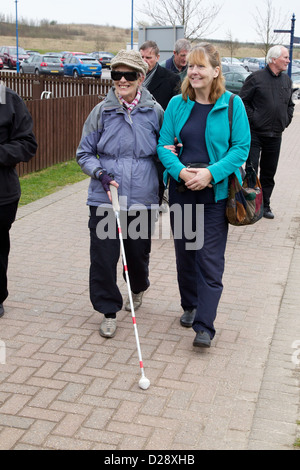 Blinde und sehbehinderte Menschen mit Betreuern auf Ausflug nach Denby Pottery. Frau mit Freiwilligen. Stockfoto