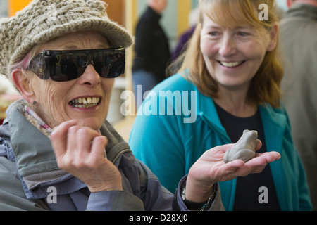 Blinde und sehbehinderte Menschen mit Betreuern auf Ausflug nach Denby Pottery. Mit Lehm Frosch. Stockfoto