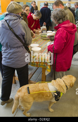 Blinde und sehbehinderte Menschen mit Betreuern auf Ausflug nach Denby Pottery. Mit Blick auf Formen. Stockfoto