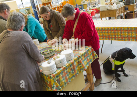 Blinde und sehbehinderte Menschen mit Betreuern auf Ausflug nach Denby Pottery. Ton Gießen in Frosch Form. Stockfoto