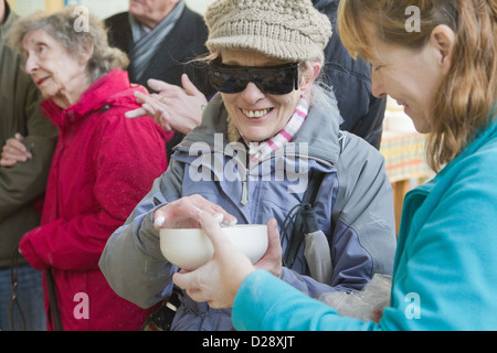 Blinde und sehbehinderte Menschen mit Betreuern auf Ausflug nach Denby Pottery. Unglasierte Schale Gefühl. Stockfoto