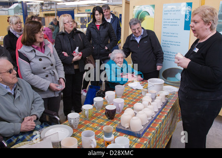 Blinde und sehbehinderte Menschen mit Betreuern auf Ausflug nach Denby Pottery. Einen Vortrag anhören. Stockfoto