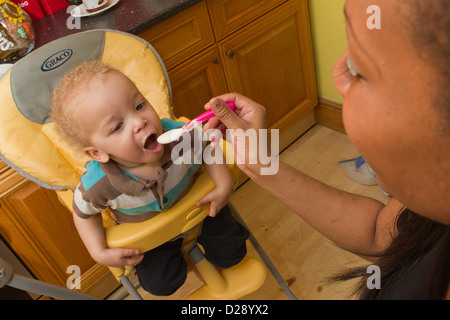 Kleinkind im Hochstuhl gefüttert Stockfoto