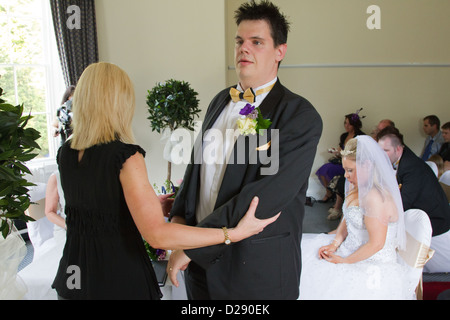 Assistenten leiten Sehbehinderte Bräutigam anmelden registrieren bei Hochzeit. Stockfoto