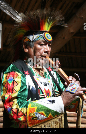 Shuswap Kulturführer indische Flötenspiel innen Grubenhaus im historischen Hat Creek Ranch Native Village, B.C.,Canada Stockfoto