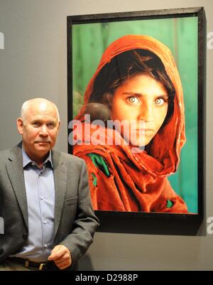 US-amerikanischer Fotograf Steve McCurry posiert vor seinem Foto "Afghanischen Mädchens" (Peshawar, Pakistan, 1984) während einer Pressekonferenz im Kunstmuseum in Wolfsburg, Deutschland, 17. Januar 2013. Die Exhibiiton zeigt einige 100 Fotografien aus asiatischen Ländern, die von 1980 bis 2011 entstanden. Foto: HOLGER HOLLEMANN Stockfoto