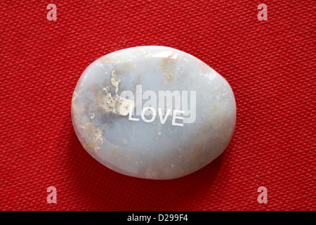 Fair-Trade-Stimmung-Kiesel - Liebe pebble isoliert auf rotem Grund Stockfoto