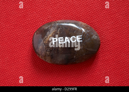 Fair-Trade-Stimmung-Kiesel - Frieden pebble isoliert auf rotem Grund Stockfoto